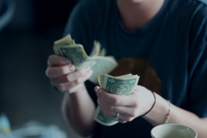 A healthcare worker counting dollar bills